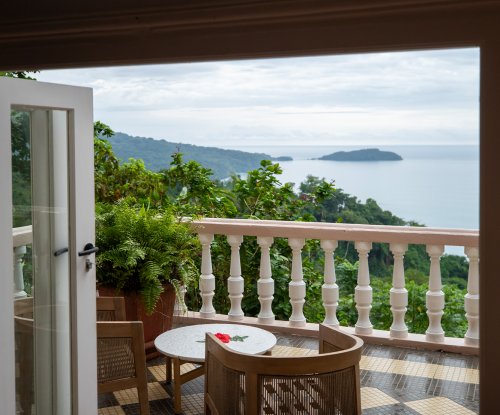 View from a Belo Monte room through French doors onto a terrace with sea and island views