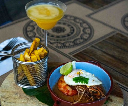 Prato de camarão com ovo estrelado, chips de banana-pão e cocktail tropical no restaurante do Omali, Ilha de São Tomé
