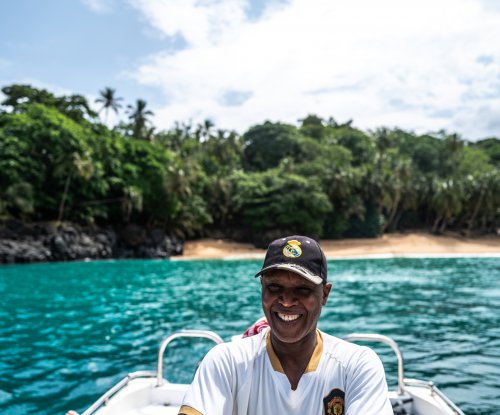 Local guide smiling on board a boat in the turquoise waters, Príncipe Island