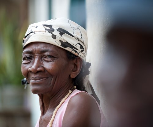 Mulher local com lenço na cabeça e sorriso caloroso, Ilha do Príncipe