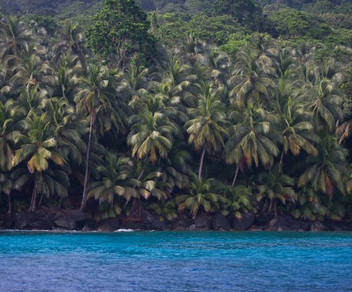 Secluded beach with dark volcanic rocks and turquoise waters on the northeastern coast, Príncipe Island