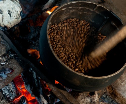 Grãos de café a serem torrados num tacho sobre lume de lenha, Ilha do Príncipe