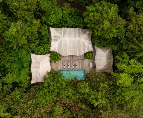 Aerial view of the Sundy Praia Pool Villa with private pool and wooden deck, nestled within the tropical rainforest, Príncipe Island
