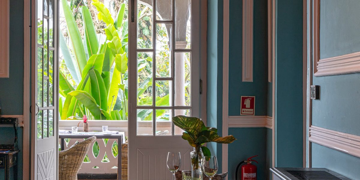 Charming room at Roça Sundy with a view of the lush garden