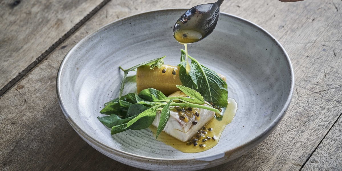 Prato de alta gastronomia apresentado numa mesa no restaurante OKA Sundy