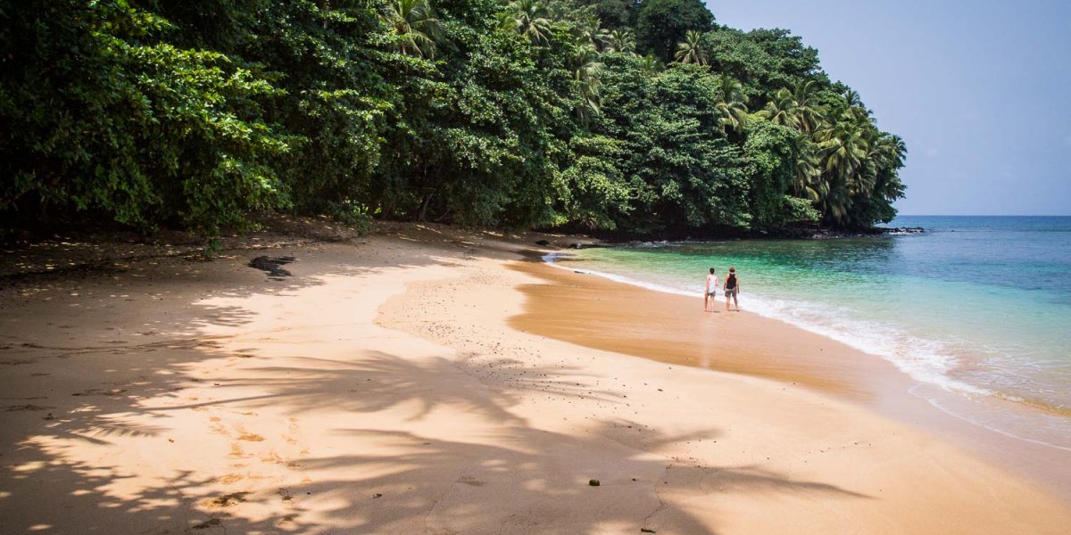 Secluded beach with turquoise water and lush forest on Príncipe Island