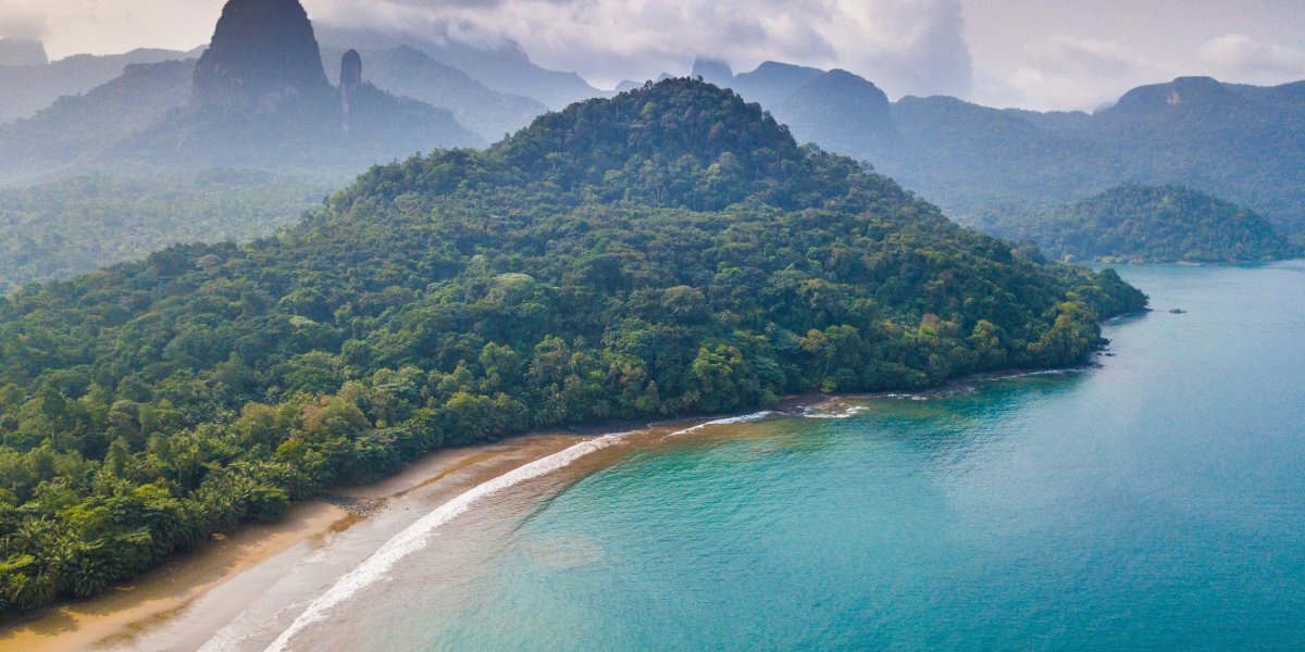Vista aérea de uma praia isolada com floresta densa na Ilha de São Tomé