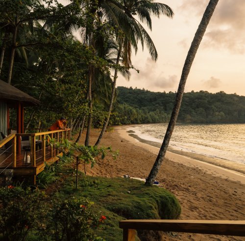 Beach view at dawn with soft golden light at Bom Bom Resort.