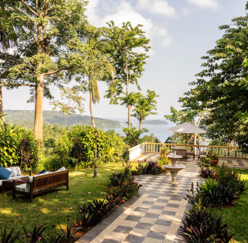 Garden terrace at Belo Monte with checkerboard path, fountain and lounge seating, overlooking the bay on Príncipe Island.