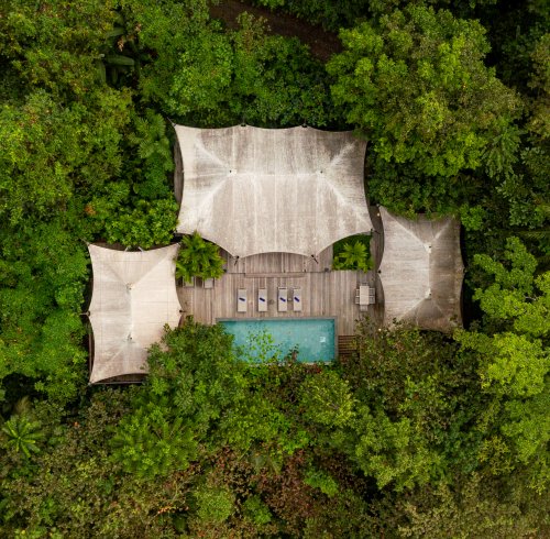 Aerial view of the Sundy Praia Pool Villa with private pool and wooden deck, nestled within the tropical rainforest, Príncipe Island