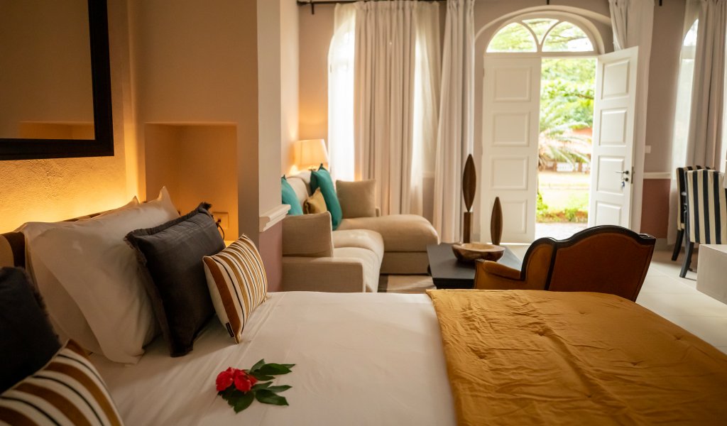 Suite Vista Jardim do Belo Monte com cama, zona de estar e portas em arco para o jardim