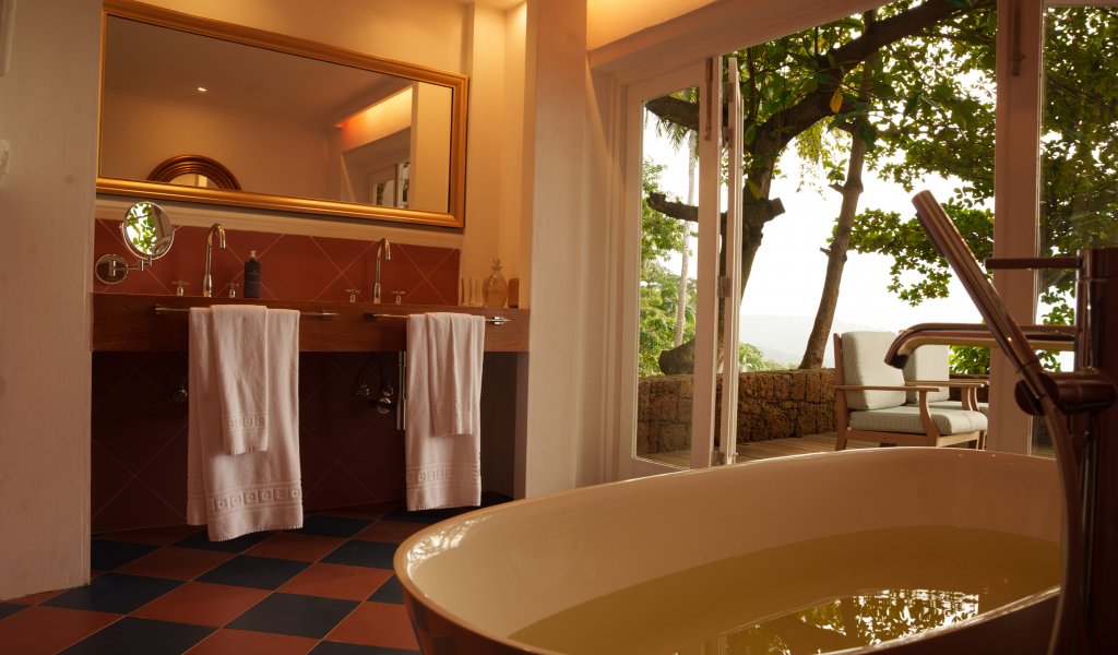 Casa de banho da Suite com Piscina Privativa do Belo Monte com banheira autónoma e portas para o deck com vista para o mar